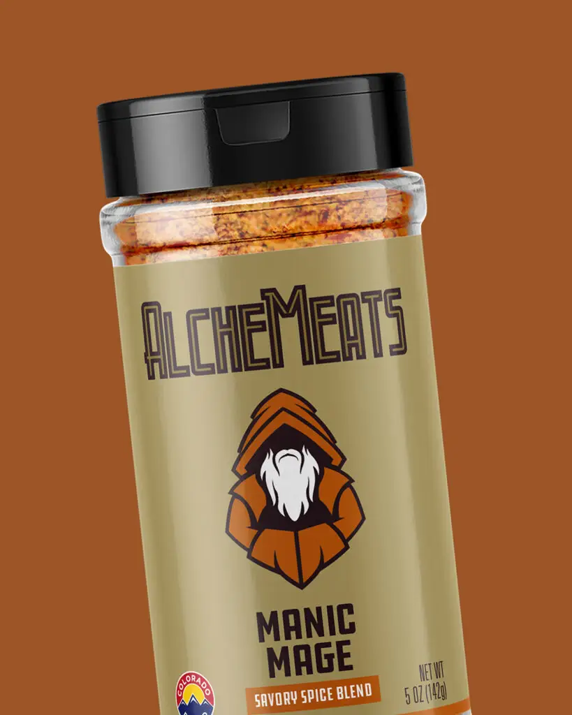 A 5oz shaker of AlcheMeats' Manic Mage Savory Spice Blend, featuring brown and orange text and designs on a gold-tan background.