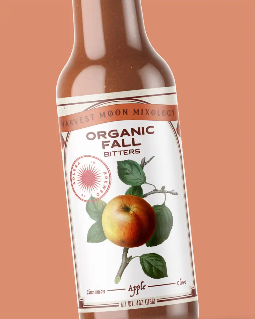 A 4oz bottle of Organic Fall Bitters by Harvest Moon Mixology, with brown text and picture of an apple against a white background.