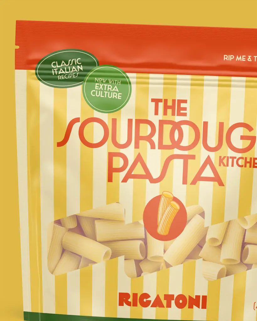 A pouch of The Sourdough Pasta Kitchen Rigatoni, with alternating yellow and pale yellow vertical stripes, orange text, and green info bubbles.