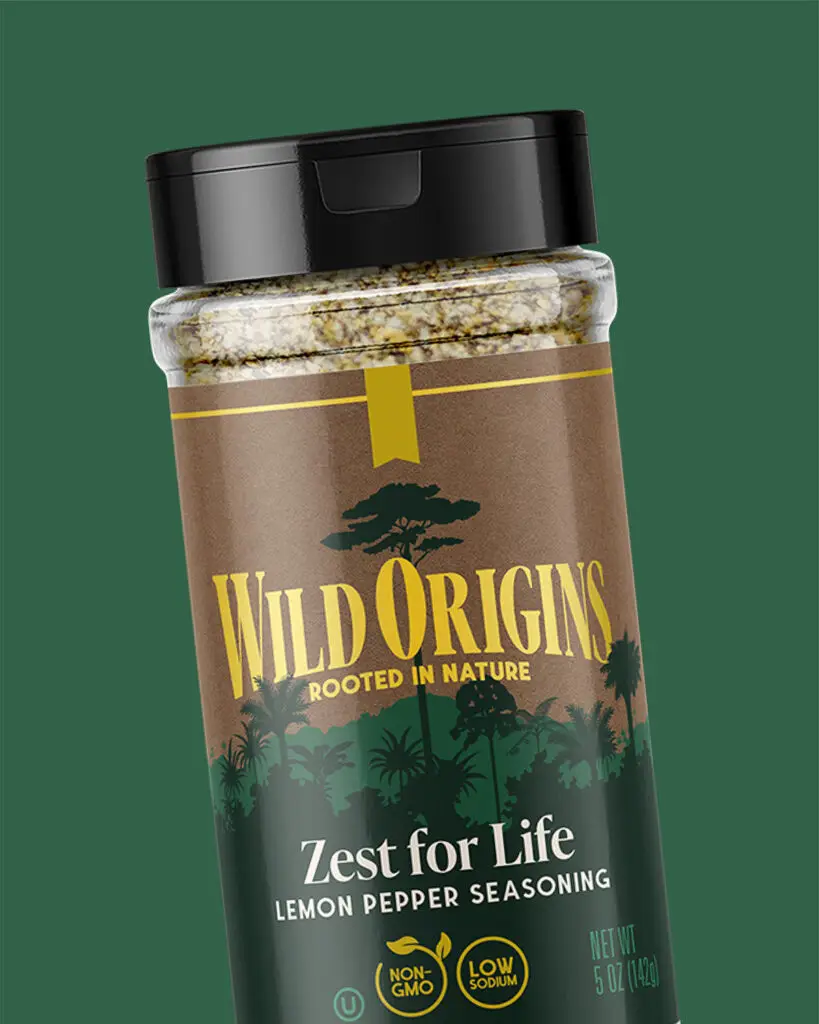 A shaker of Wild Origins' Zest for Life lemon pepper seasoning, featuring yellow text and a forest overlaid on a brown background.